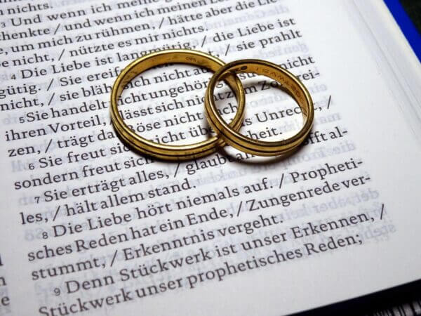 Zwei goldene Ringe auf einer aufgeschlagenen Buchseite mit deutschem Text.